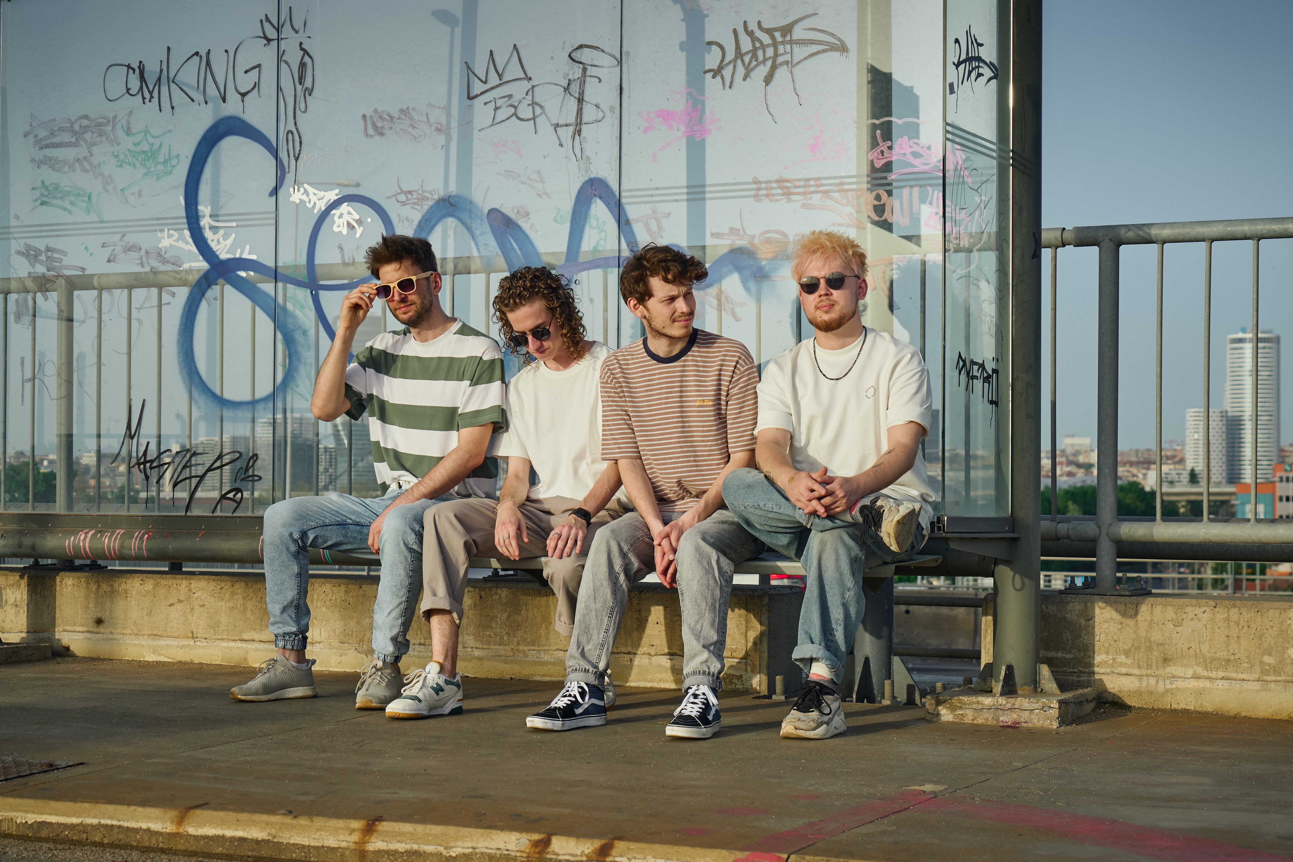 The four members of Upper! Upper! sitting together outdoors